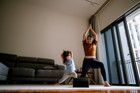 Mom and daughter stretching in living room