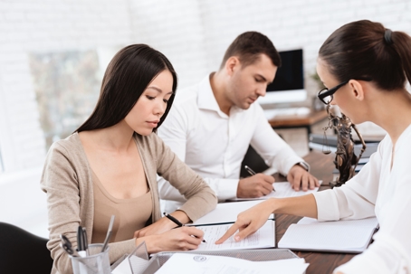 couple signing documents in lawyer's office